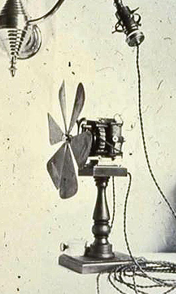 A photo of an early fan with a lightbulb socket connecting cord
